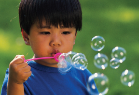 child blowing bubbles